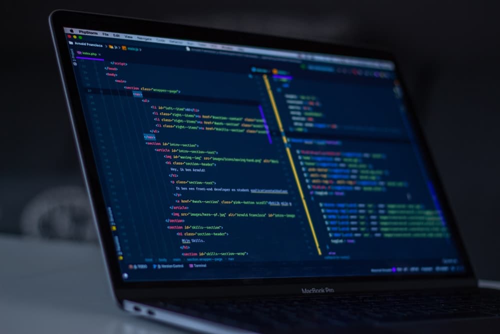 Software engineer coding and reviewing system architecture on monitor screens